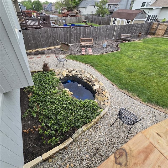 view of yard featuring a garden pond, a residential view, and a fenced backyard