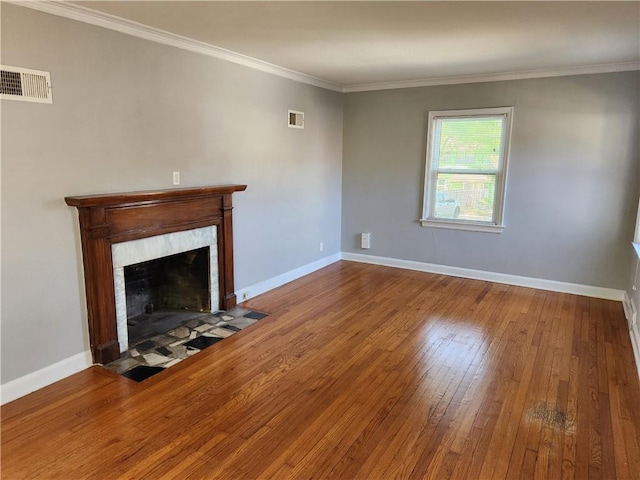 unfurnished living room with hardwood / wood-style floors, a fireplace, baseboards, and ornamental molding
