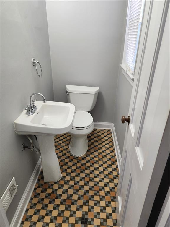 bathroom featuring baseboards and toilet