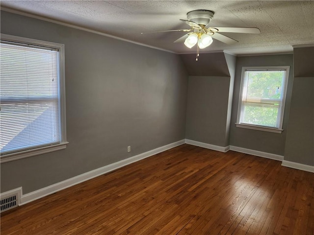 unfurnished room featuring dark wood-style flooring, ceiling fan, crown molding, and baseboards