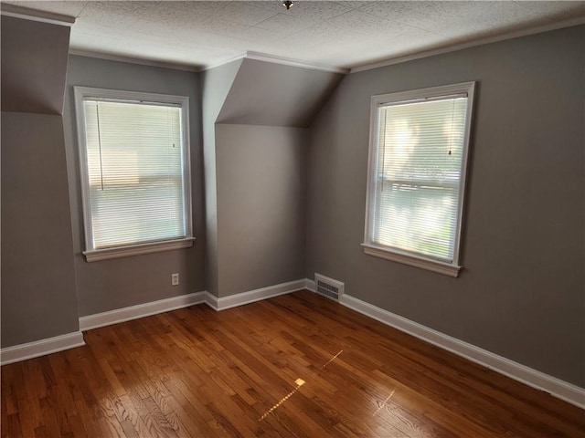 additional living space with dark wood-style floors, baseboards, and vaulted ceiling