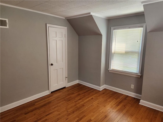 additional living space featuring hardwood / wood-style flooring and baseboards