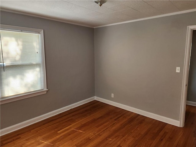 empty room with ornamental molding, dark wood-type flooring, plenty of natural light, and baseboards