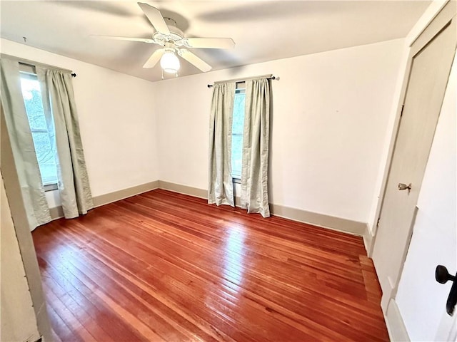 1420 N Mulberry St, Maryville, MO 64468 - unfurnished bedroom with multiple windows, hardwood / wood-style floors, baseboards, and ceiling fan