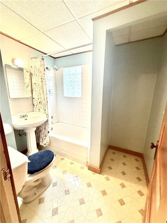 1420 N Mulberry St, Maryville, MO 64468 - full bathroom featuring toilet, shower / bath combination with curtain, tile patterned floors, baseboards, and a paneled ceiling