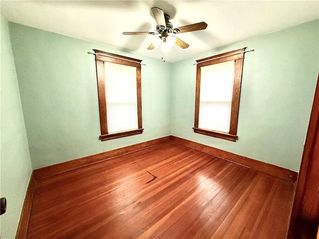 1420 N Mulberry St, Maryville, MO 64468 - empty room featuring dark wood finished floors, plenty of natural light, a ceiling fan, and baseboards