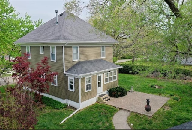 1420 N Mulberry St, Maryville, MO 64468 - back of property featuring roof with shingles, a patio, and a yard