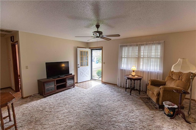 802 Cherry St, Lamar, MO 64759 - carpeted living area featuring visible vents, a textured ceiling, and ceiling fan