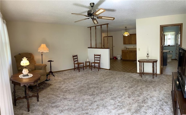 802 Cherry St, Lamar, MO 64759 - sitting room featuring carpet floors, a textured ceiling, ceiling fan, and baseboards