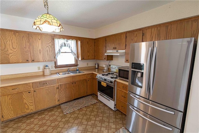 802 Cherry St, Lamar, MO 64759 - kitchen with brown cabinetry, a sink, light countertops, under cabinet range hood, and stainless steel appliances