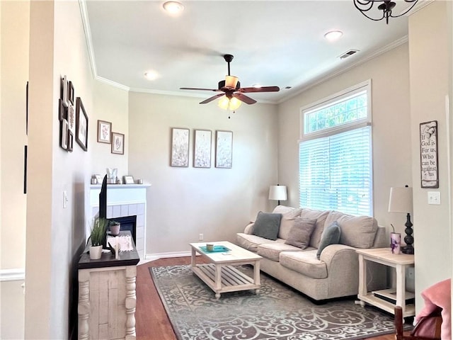 428 W Sycamore St, Nevada, MO 64772 - living room with crown molding, wood finished floors, a ceiling fan, a tile fireplace, and recessed lighting