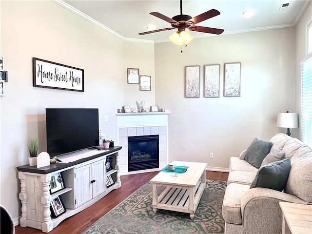 428 W Sycamore St, Nevada, MO 64772 - living room with a ceiling fan, dark wood-type flooring, a tile fireplace, ornamental molding, and baseboards