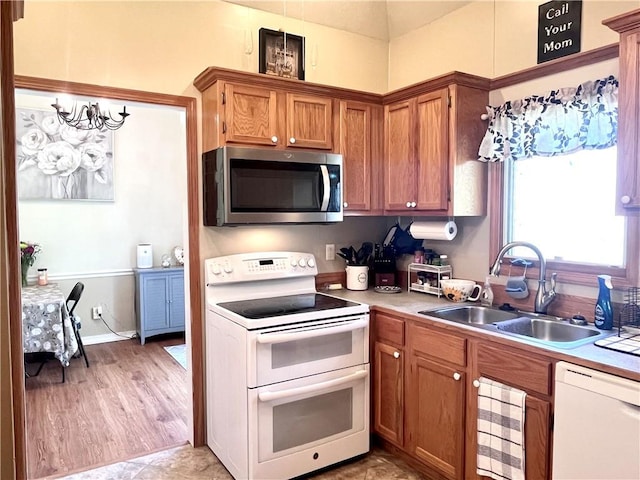 428 W Sycamore St, Nevada, MO 64772 - kitchen featuring white appliances, a sink, brown cabinetry, and light countertops