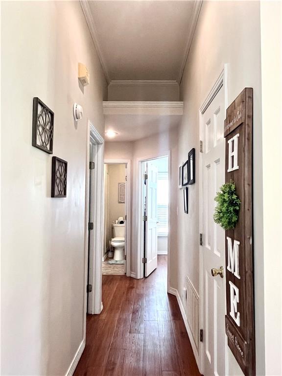 428 W Sycamore St, Nevada, MO 64772 - hallway with ornamental molding, dark wood-type flooring, and baseboards