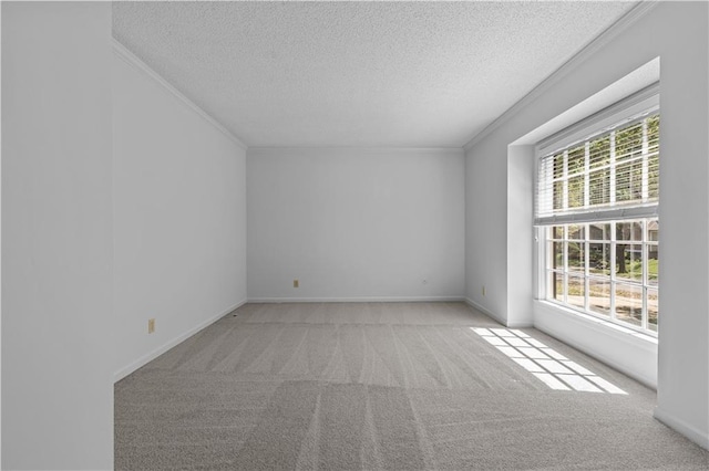 unfurnished room featuring a textured ceiling, ornamental molding, carpet, and baseboards
