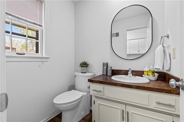 bathroom featuring visible vents, wood finished floors, toilet, and vanity