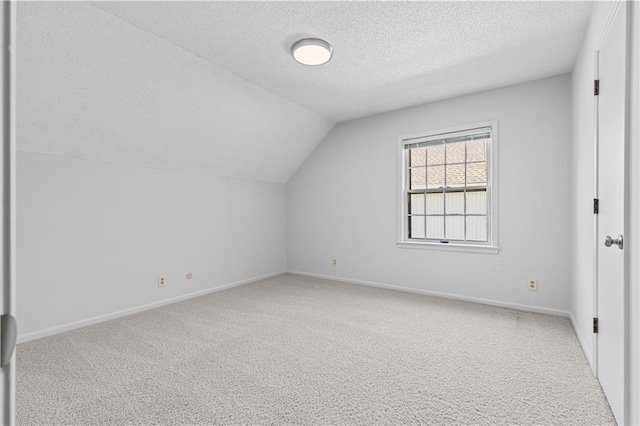 bonus room with baseboards, a textured ceiling, lofted ceiling, and carpet flooring