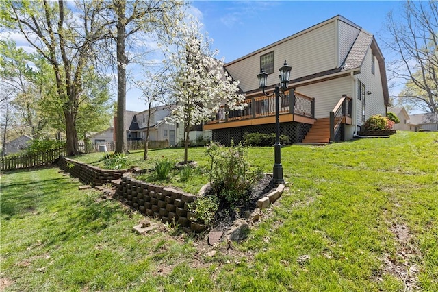 rear view of property with fence, a yard, and a wooden deck