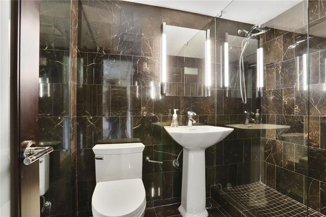 310 W 49th St Unit 705, Kansas City, MO 64112 - bathroom with tile walls, toilet, and tiled shower