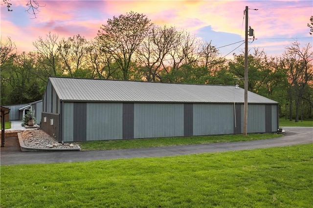 11155 Hubbard Rd, Kansas City, KS 66109 - outdoor structure at dusk with a lawn and an outbuilding
