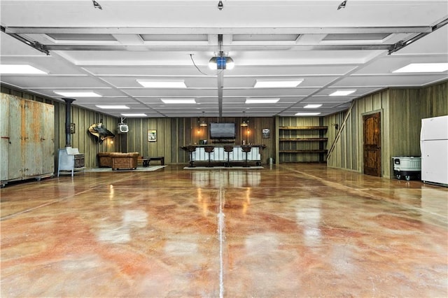 11155 Hubbard Rd, Kansas City, KS 66109 - miscellaneous room with a garage, concrete flooring, and wooden walls