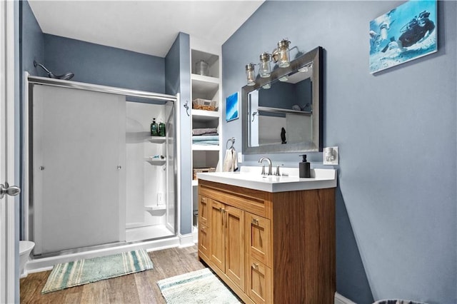 11155 Hubbard Rd, Kansas City, KS 66109 - bathroom with a shower stall, wood finished floors, vanity, and toilet