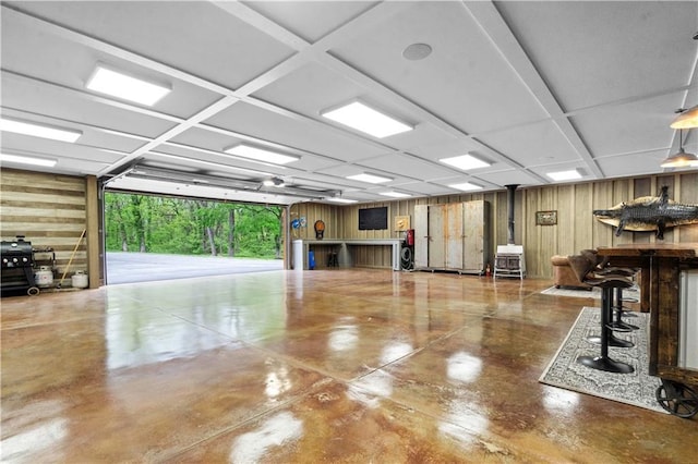 11155 Hubbard Rd, Kansas City, KS 66109 - garage featuring wood walls and a wood stove