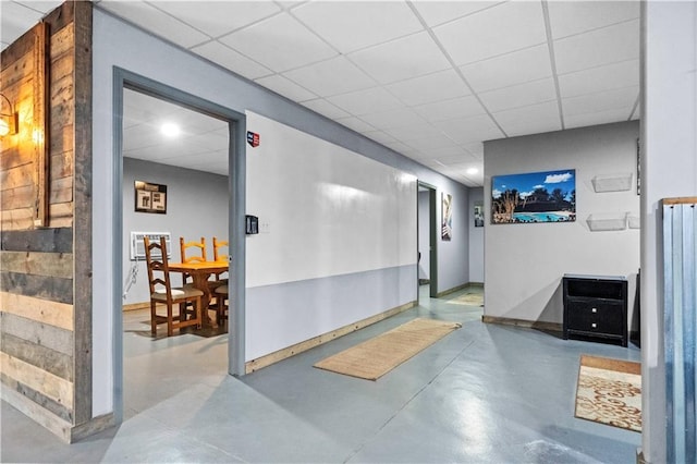 11155 Hubbard Rd, Kansas City, KS 66109 - corridor with concrete floors, baseboards, and a paneled ceiling