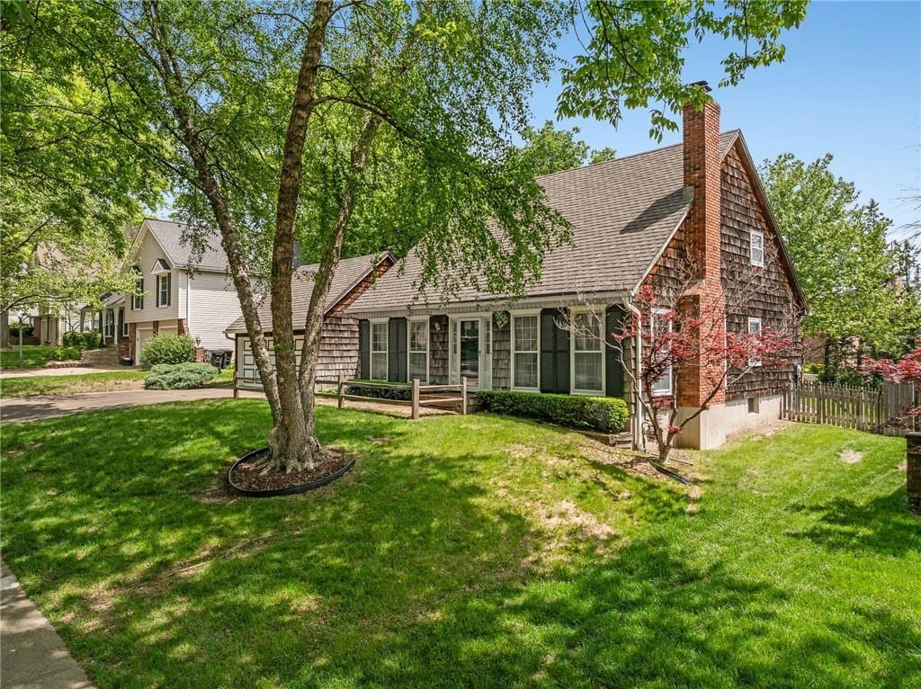 11631 Kenwood Ave, Kansas City, MO 64131 - view of front facade featuring roof with shingles and a chimney