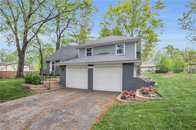 garage featuring fence and aphalt driveway