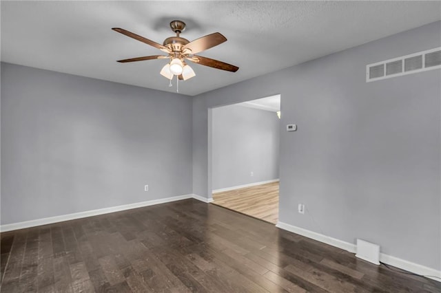 unfurnished room featuring visible vents, baseboards, ceiling fan, and wood finished floors