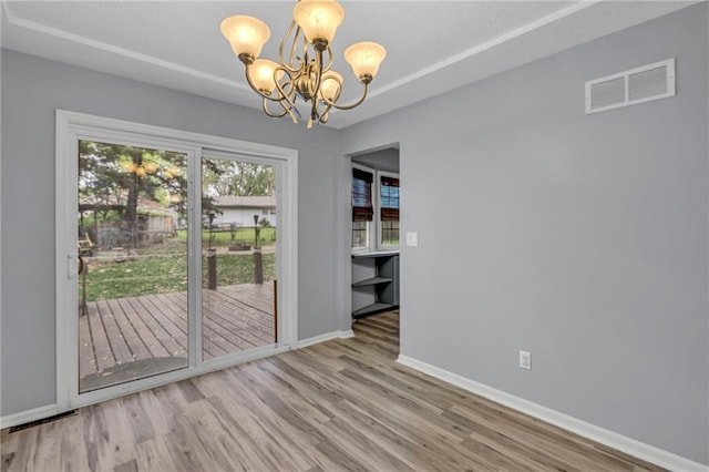 doorway to outside with a chandelier, baseboards, visible vents, and wood finished floors