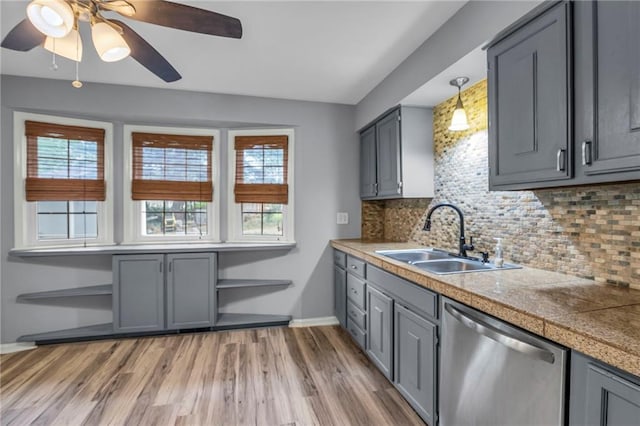 kitchen featuring tile countertops, gray cabinets, a sink, and dishwasher
