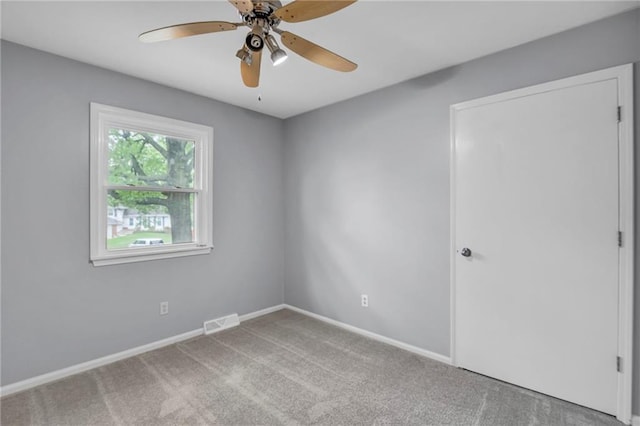 unfurnished room with baseboards, visible vents, ceiling fan, and carpet