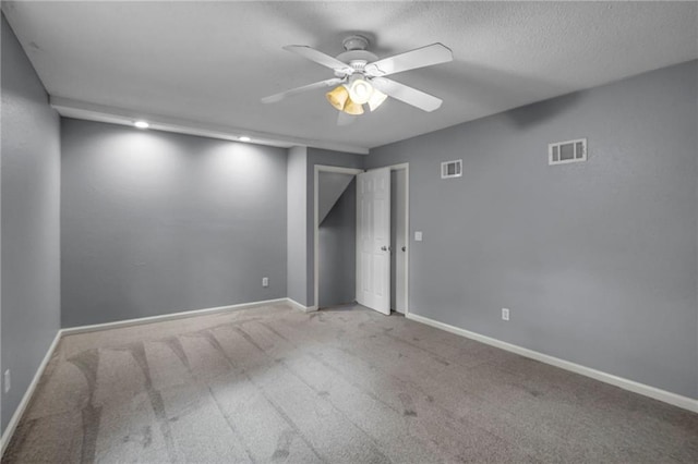 unfurnished room featuring baseboards, a ceiling fan, carpet flooring, and visible vents