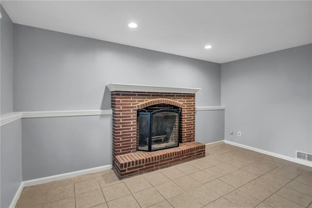 unfurnished living room featuring baseboards, tile patterned flooring, a fireplace, and visible vents