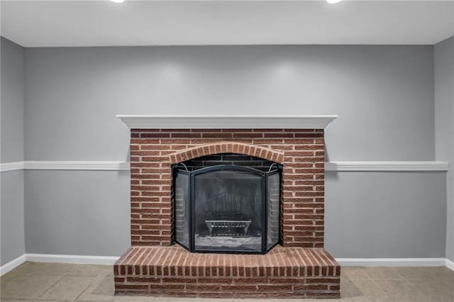 interior details featuring baseboards, a brick fireplace, and recessed lighting