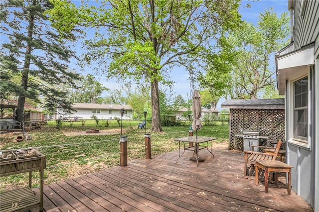 deck with a fenced backyard, a yard, and grilling area