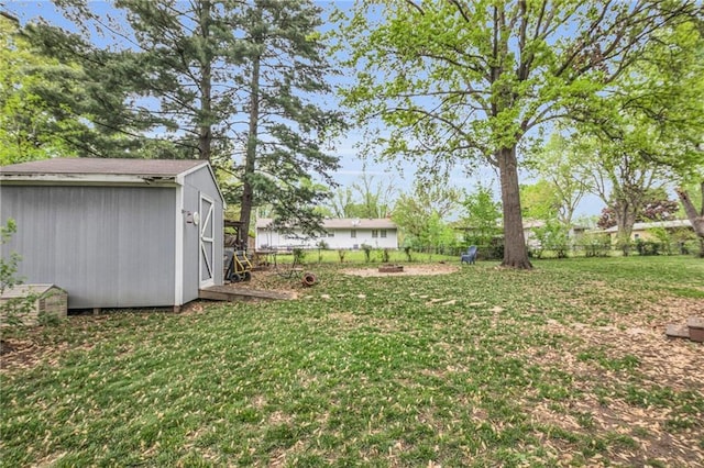 view of yard featuring an outdoor structure, fence, and a shed