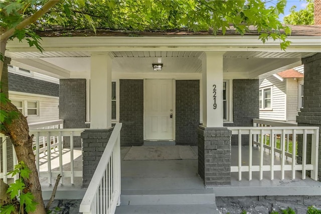 2219 E Meyer Blvd, Kansas City, MO 64132 - view of exterior entry featuring covered porch and brick siding