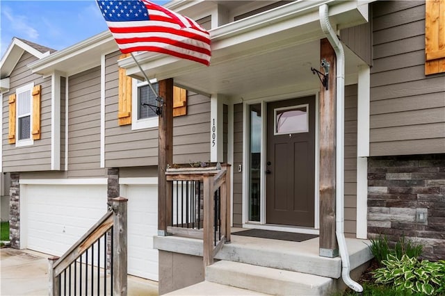 view of exterior entry featuring concrete driveway and a garage