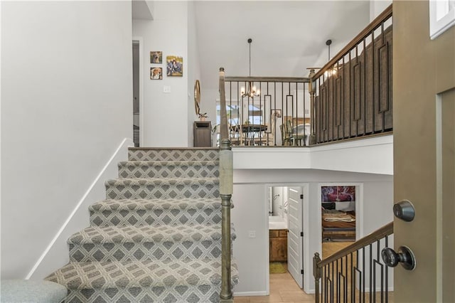 staircase featuring a chandelier and a high ceiling