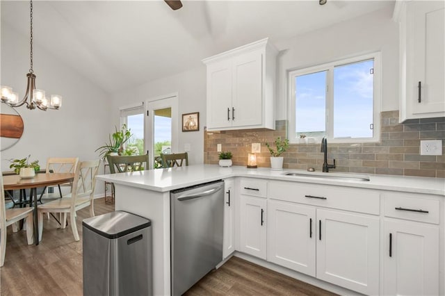 kitchen featuring lofted ceiling, dishwasher, a sink, dark wood-type flooring, and tasteful backsplash