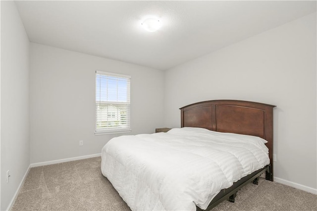 bedroom with light carpet and baseboards