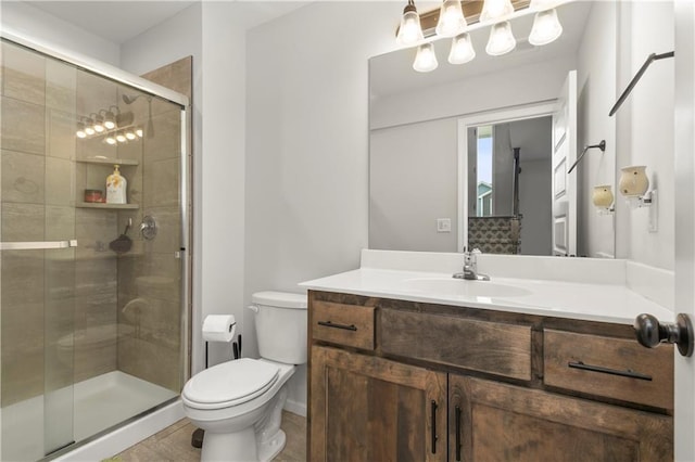 bathroom with a stall shower, vanity, and toilet