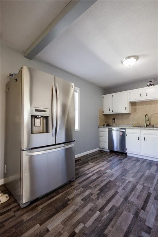 kitchen with a sink, dark wood finished floors, baseboards, white cabinetry, and appliances with stainless steel finishes