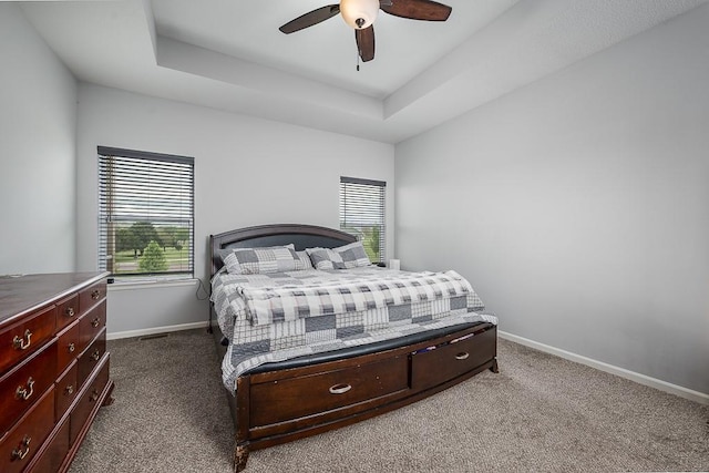 bedroom with baseboards, dark colored carpet, and multiple windows