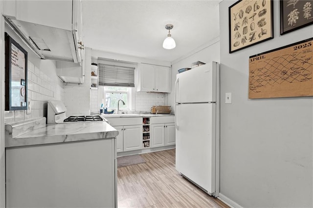 510 E Park St, Olathe, KS 66061 - kitchen featuring freestanding refrigerator, range, light countertops, white cabinetry, and backsplash