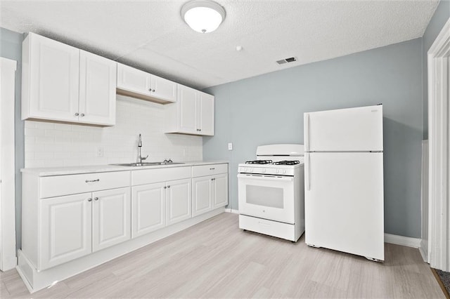 510 E Park St, Olathe, KS 66061 - kitchen featuring white appliances, light countertops, decorative backsplash, white cabinets, and light wood-style floors