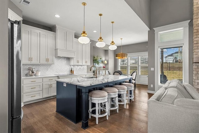 21410 W 189th Ter, Spring Hill, KS 66083 - kitchen featuring a sink, a breakfast bar, white cabinetry, dark wood-style floors, and recessed lighting